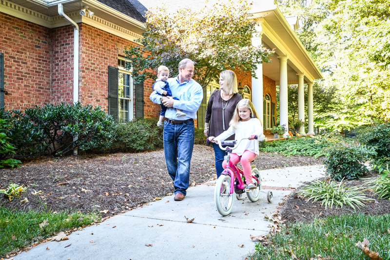 A family having fun in front of their home.