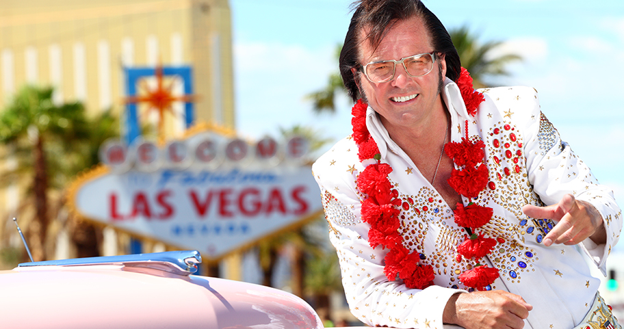 An Elvis impersonator in front of a Las Vegas sign.