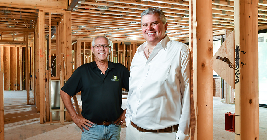 Two men stand inside a new construction home