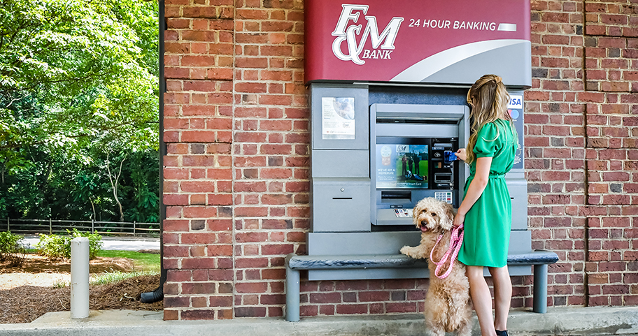 A woman brings her dog with her to the F&M Bank ATM 