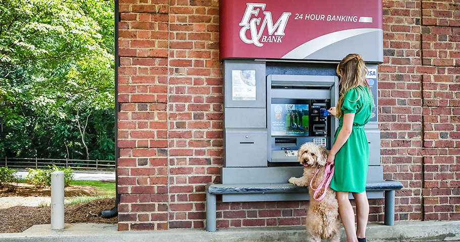 A woman brings her dog with her to the F&M Bank ATM