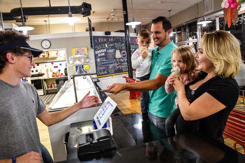 A father paying for ice cream for his family with his debit card.