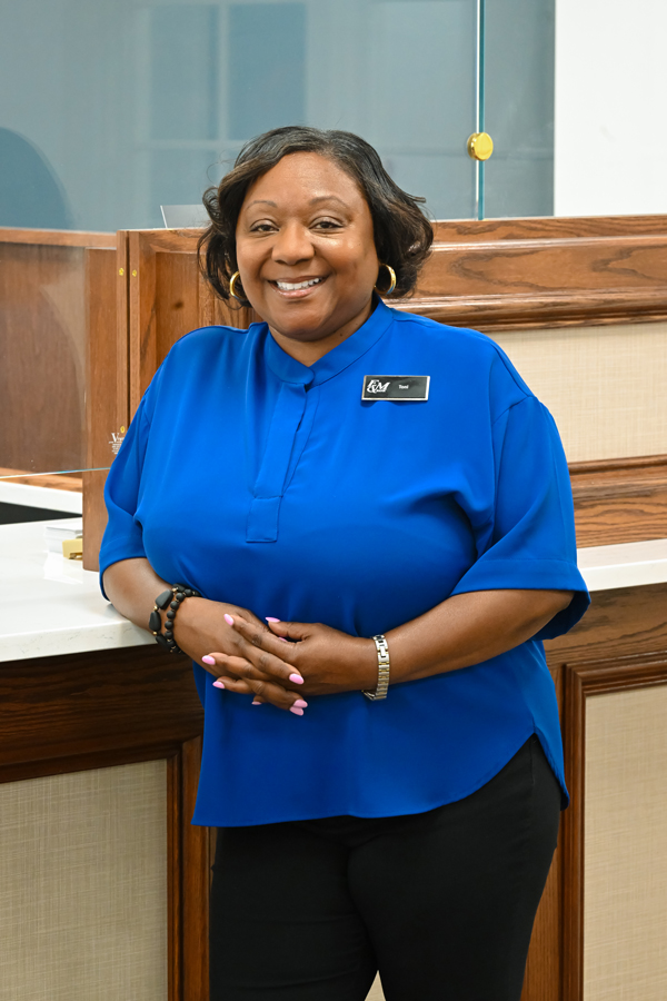 A F&M Bank employee standing in the office smiling