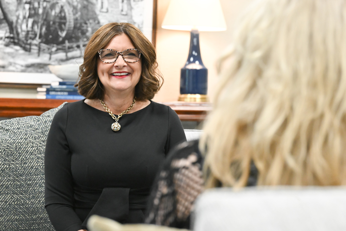 A person sitting in a chair smiling at F&M Bank.