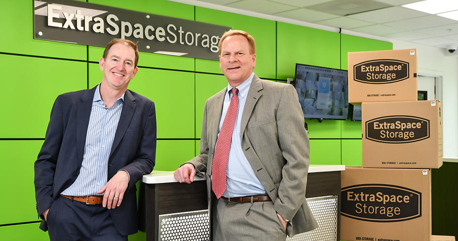 Two men standing by a desk at their business