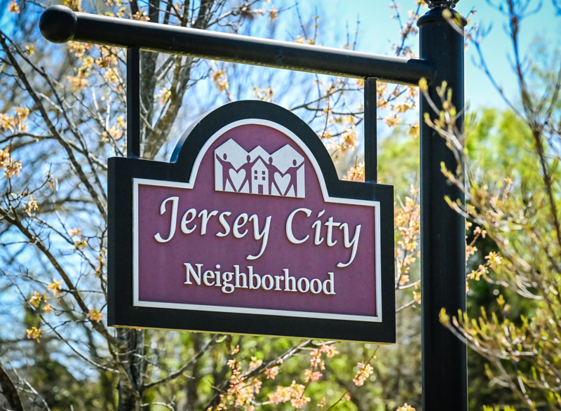 Jersey City neighborhood sign with trees in the background