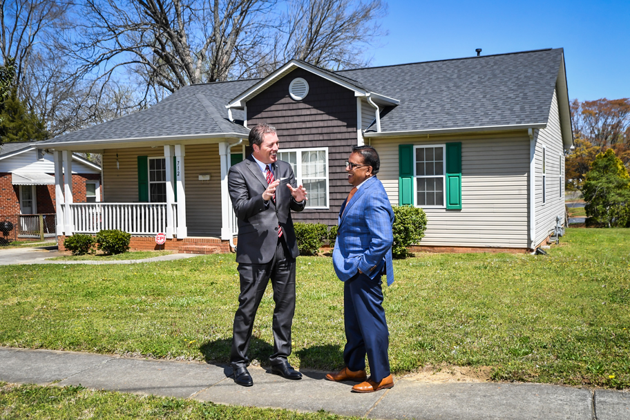 F&M Bank CEO Steve Fisher and Chanaka Yatawara, Executive Director of Salisbury Community Development Corporation, talking in front of a house in the Jersey City neighborhood