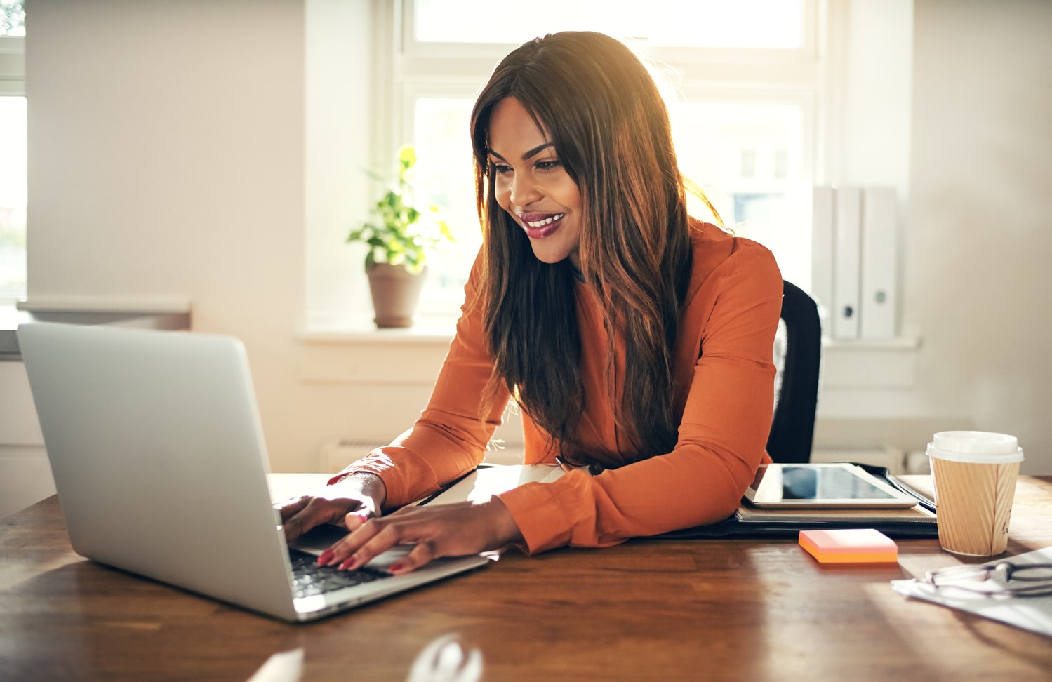 A person smiling while looking at their laptop.