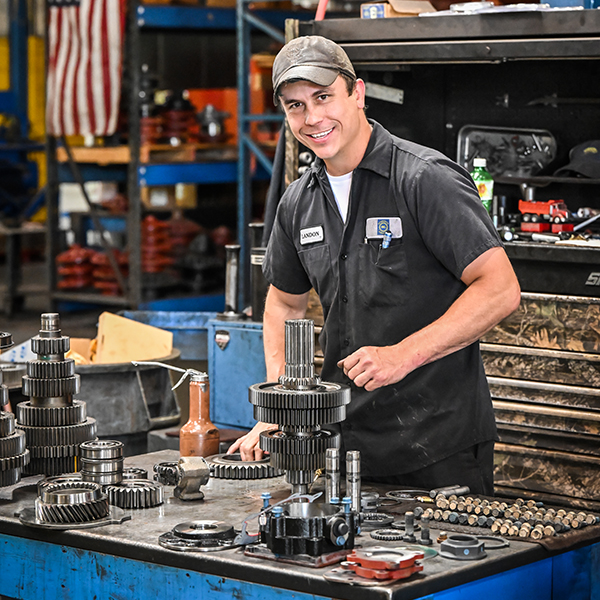 A technician working on motor parts for a vehicle.