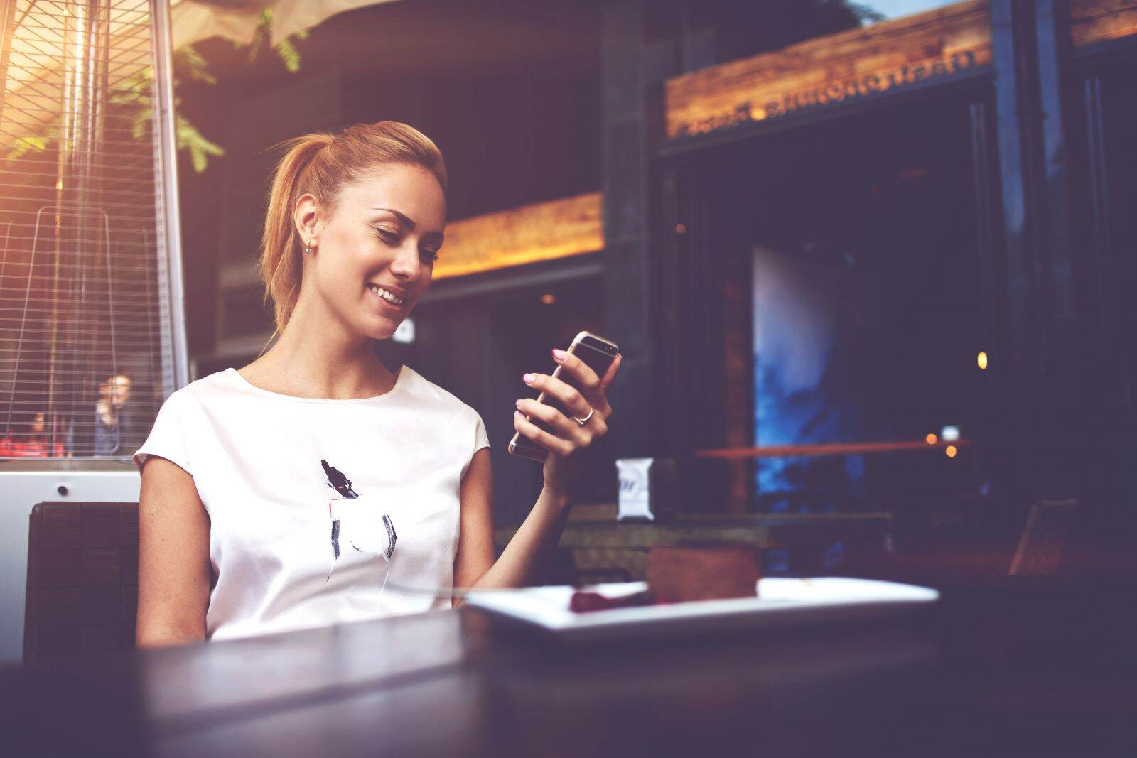 A person looking down at their phone and smiling.