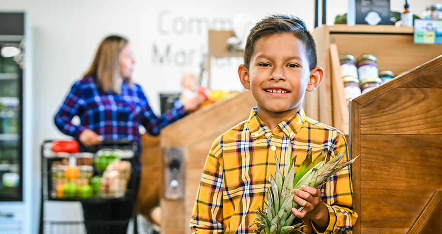 A mother and her son shop for produce at the local Community Marketplace