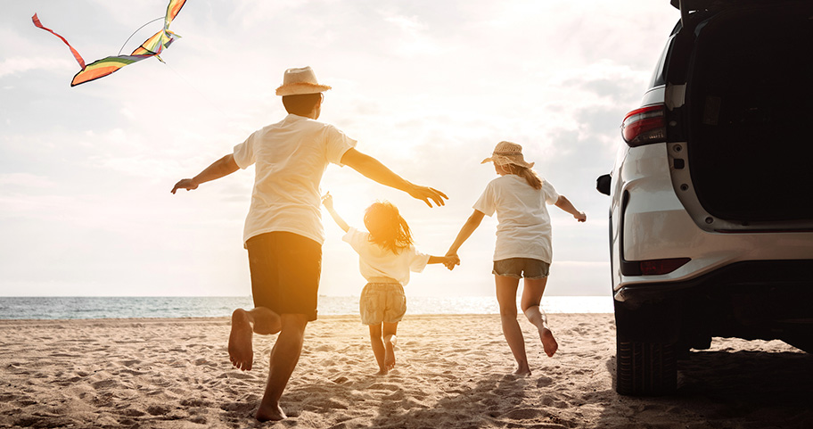 Family on the beach flying a kite.