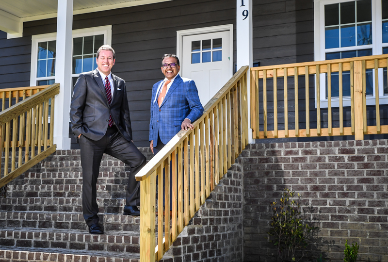 F&M Bank CEO Steve Fisher and Chanaka Yatawara, Executive Director of Salisbury Community Development Corporation, stand on the stairs of a home in Jersey City 