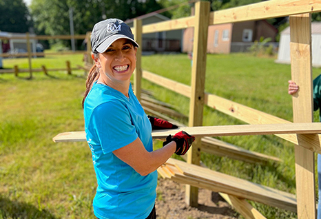 A person building a fence in their community.