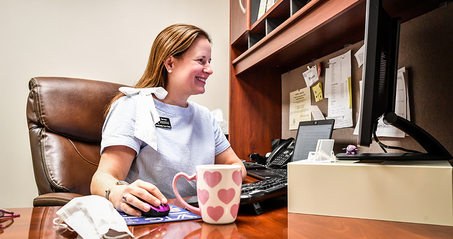 A F&M Bank employee working on the computer at the office.